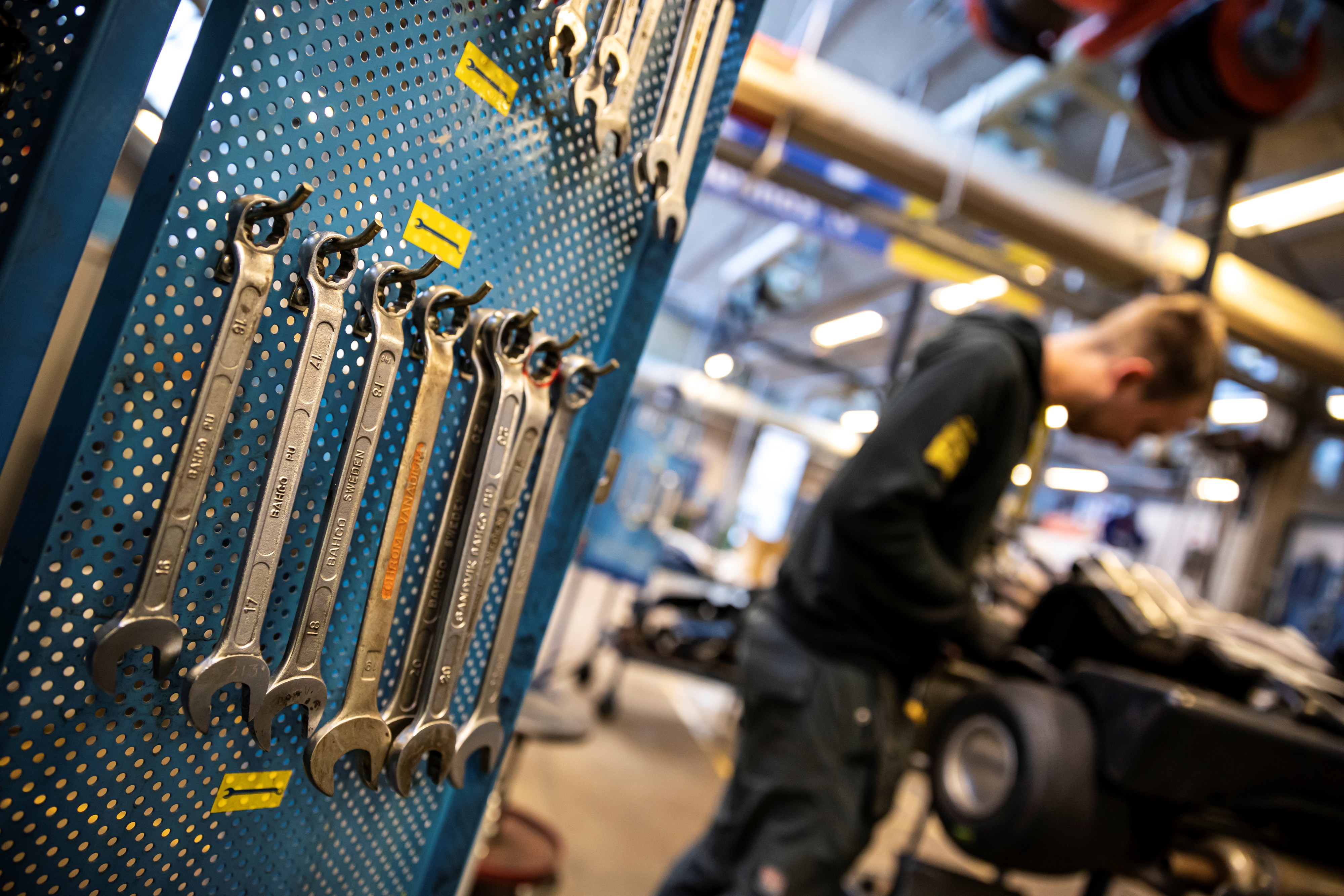 Nærbillede af værktøj. I baggrunden arbejder elev.